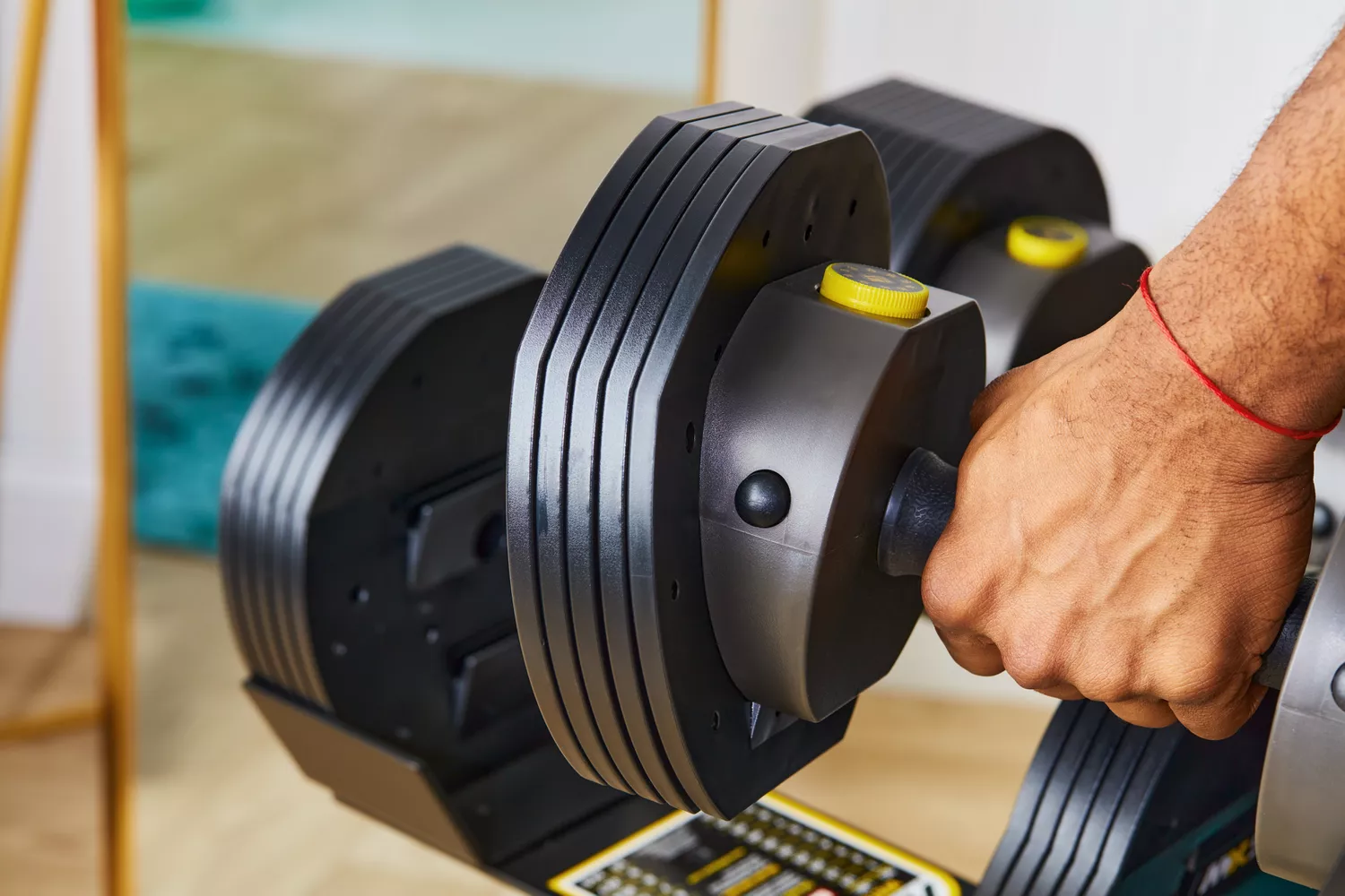 Hand holding MX55 Rapid Change Adjustable Dumbbells 