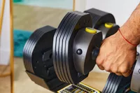 Hand holding MX55 Rapid Change Adjustable Dumbbells 