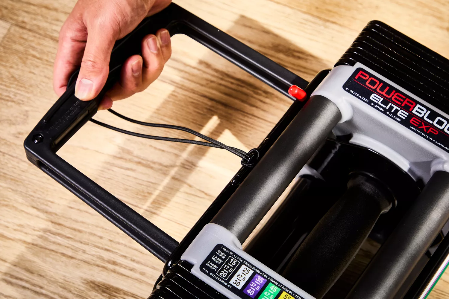 hand adjusting the weight on the POWERBLOCK Elite EXP Adjustable Dumbbell