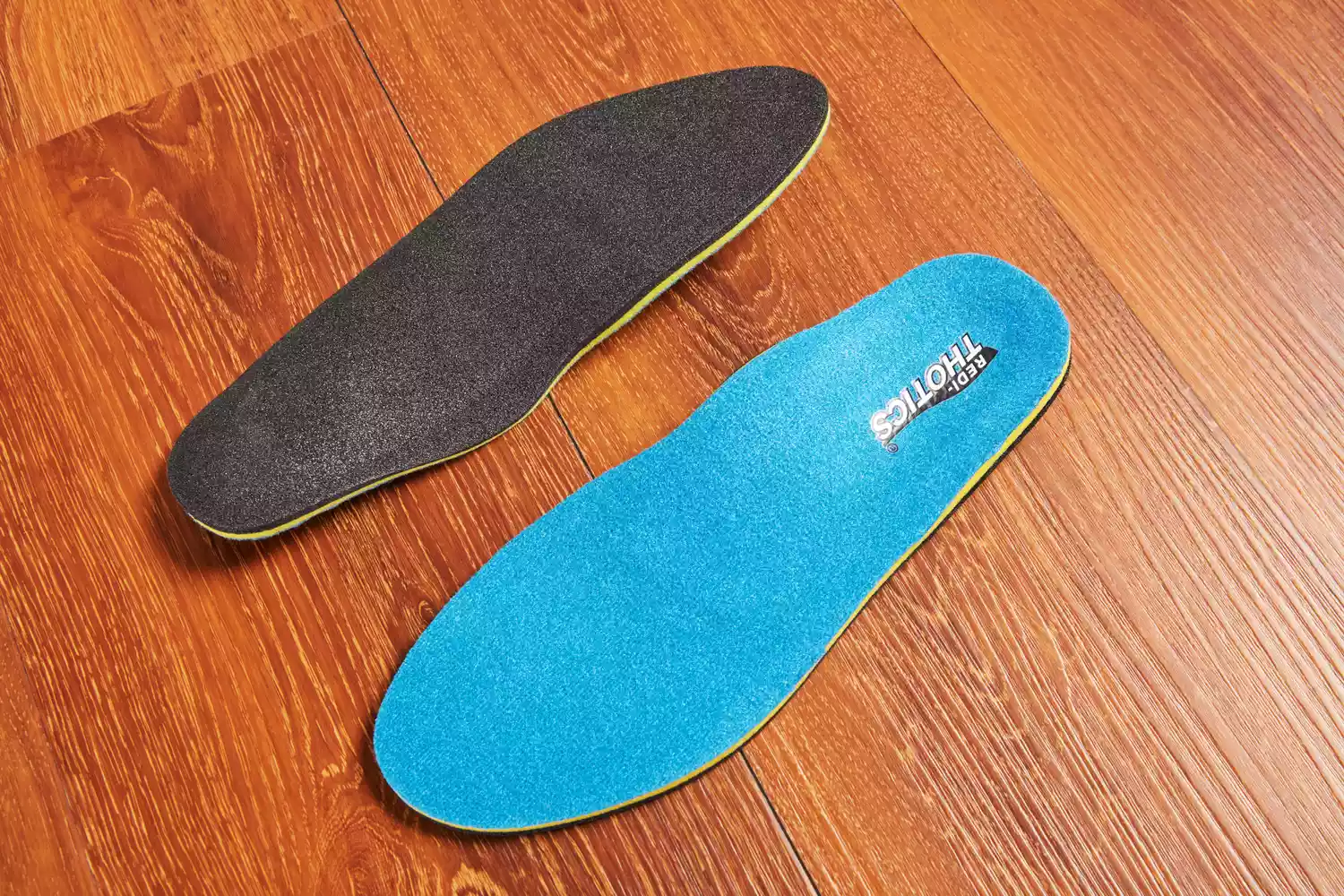 Top and bottom of Redi-Thotics Flex Orthotic Insoles displayed on a wood floor