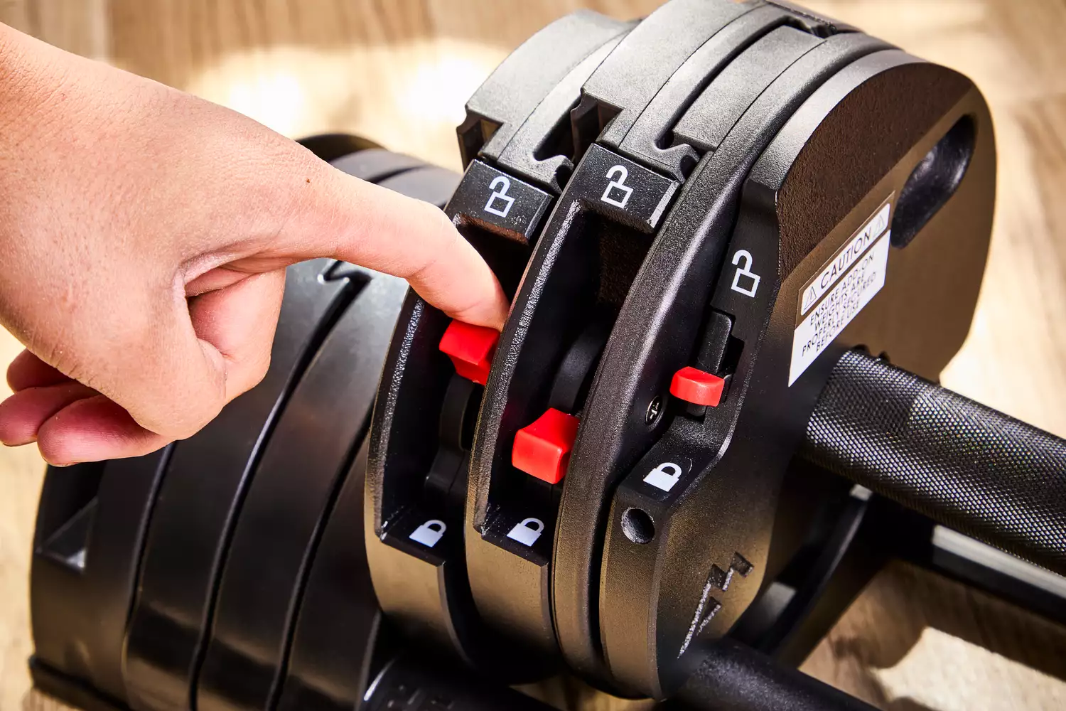 A person adjusts the weight on the Rep Fitness Quickdraw Adjustable Dumbbell