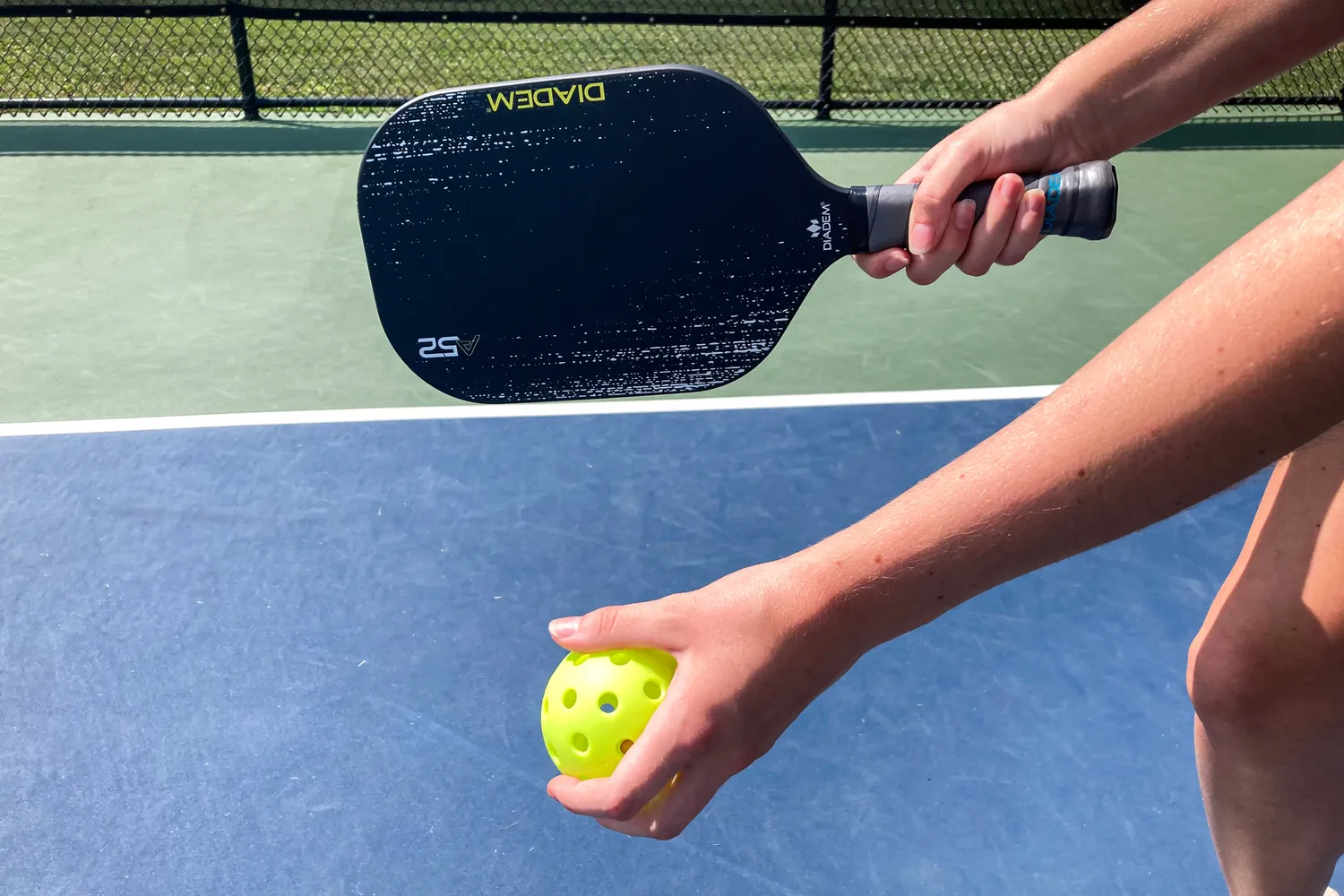 A person hits a pickleball with the Diadem A52 Pickleball Paddle