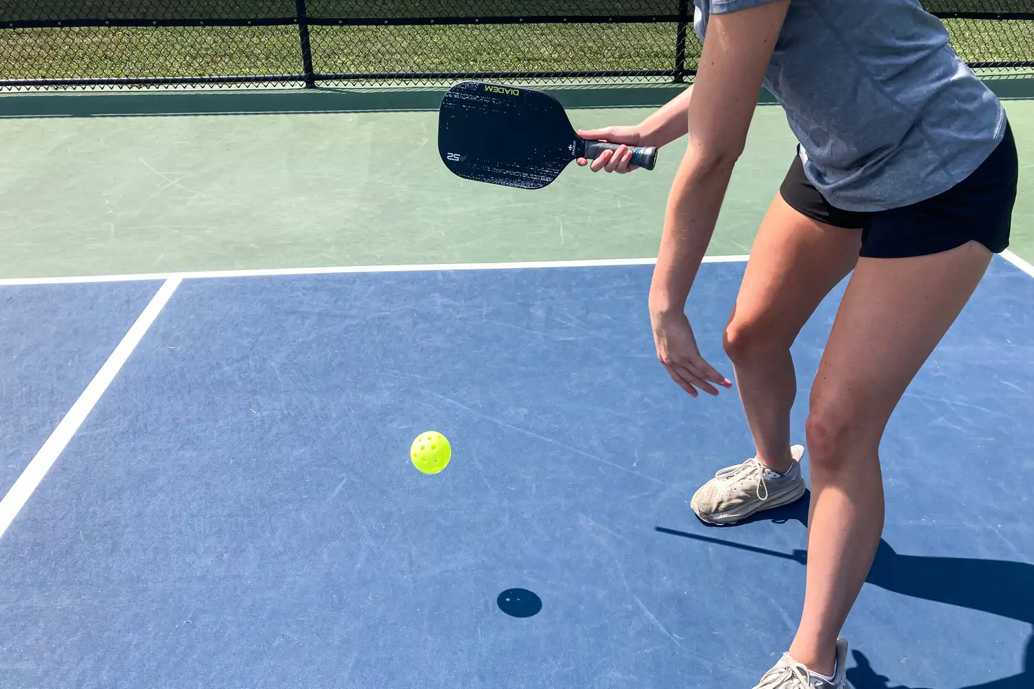 A person hits a pickleball with the Diadem A52 Pickleball Paddle
