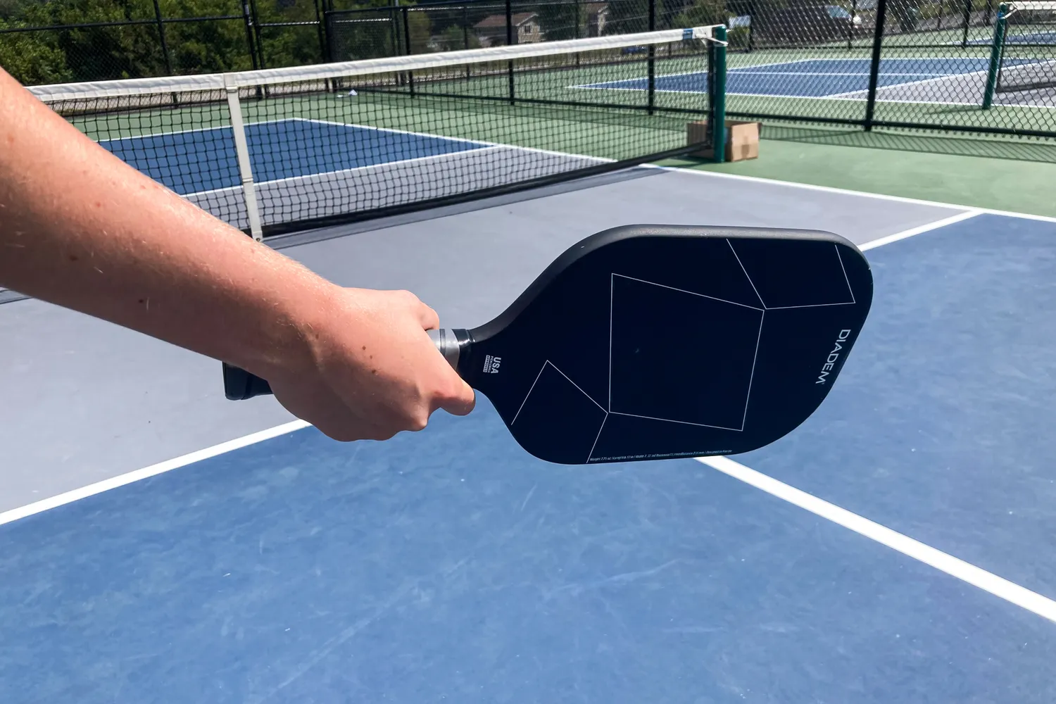 A person plays pickleball with the Diadem A52 Pickleball Paddle