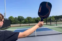 A person holds the Diadem Icon Infinity Pro Pickleball Paddle in the air