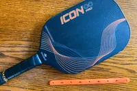 The Diadem Icon Infinity Pro Pickleball Paddle on a wooden table