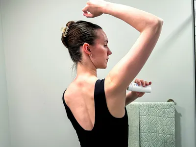 A person applies Dove VitaminCare+ Deodorant Stick to their underarm