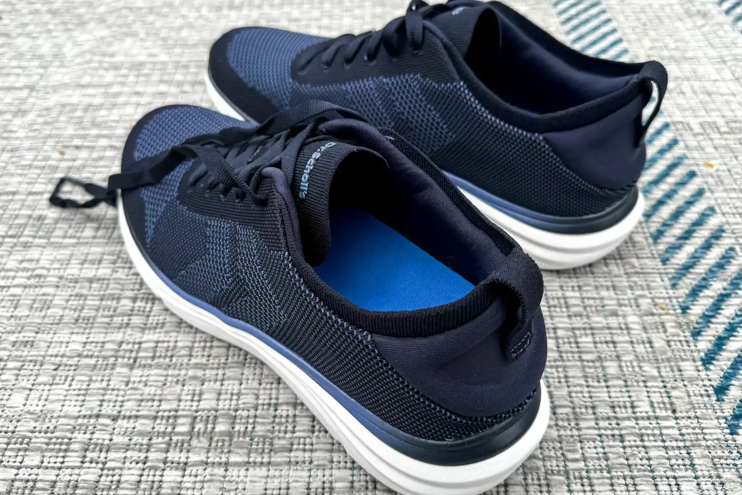 A pair of Dr. Scholl's Men's Feel Ready Lace Up Sneakers with the laces untied