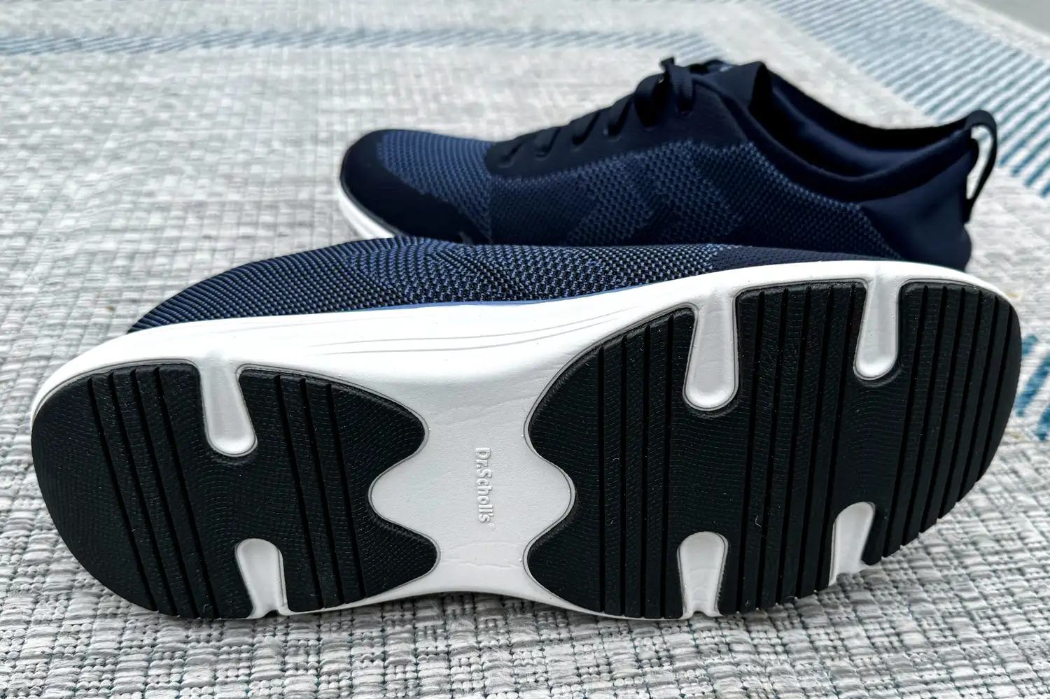 A pair of Dr. Scholl's Men's Feel Ready Lace Up Sneakers showing the treads 