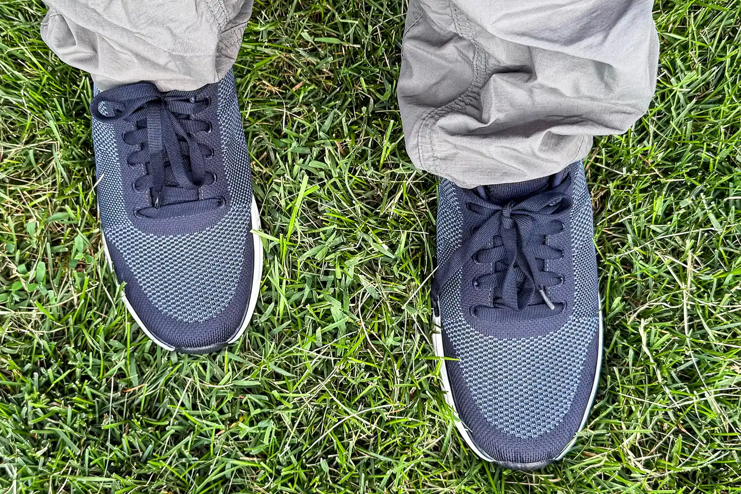 A overhead view of a person wearing the Dr. Scholl's Men's Feel Ready Lace Up Sneakers in grass