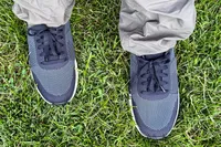 A overhead view of a person wearing the Dr. Scholl's Men's Feel Ready Lace Up Sneakers in grass