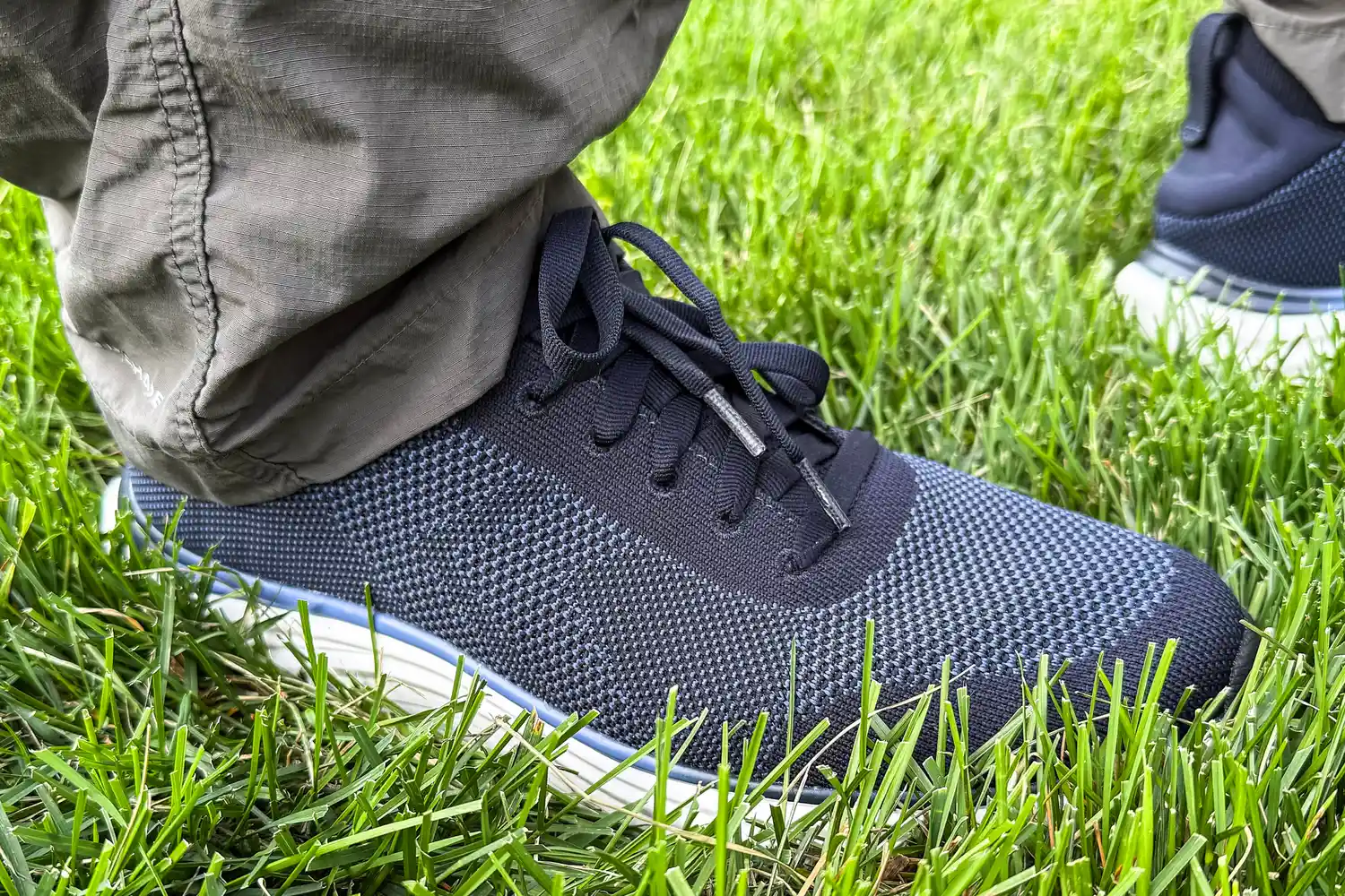 A person wearing Dr. Scholl's Men's Feel Ready Lace Up Sneakers on grass