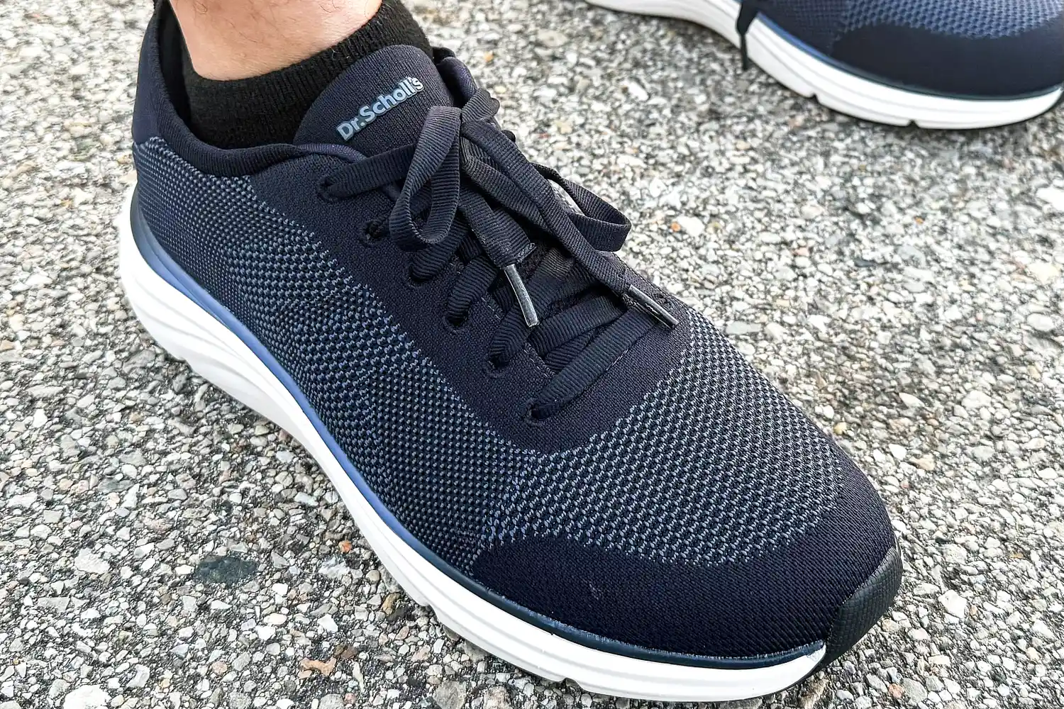 A close-up of a person wearing the Dr. Scholl's Men's Feel Ready Lace Up Sneakers