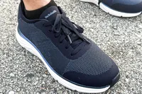 A close-up of a person wearing the Dr. Scholl's Men's Feel Ready Lace Up Sneakers