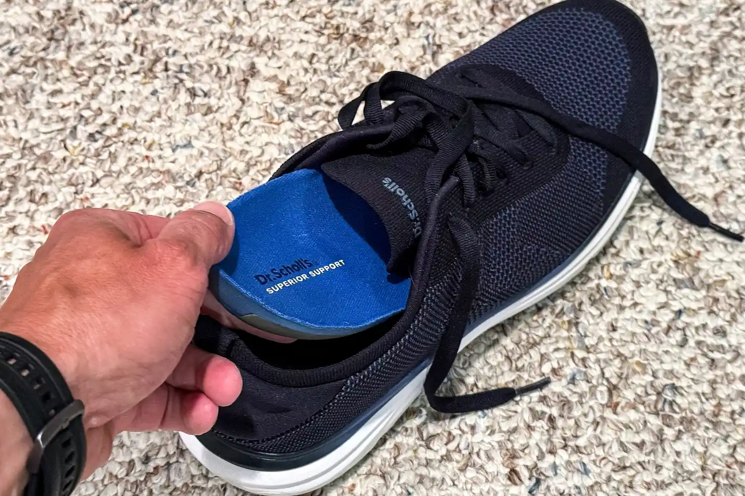 A person places an insole into the Dr. Scholl's Men's Feel Ready Lace Up Sneakers