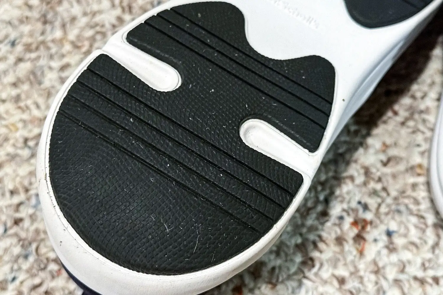 The sole of a Dr. Scholl's Men's Feel Ready Lace Up Sneaker on a carpeted floor