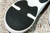 The sole of a Dr. Scholl's Men's Feel Ready Lace Up Sneaker on a carpeted floor