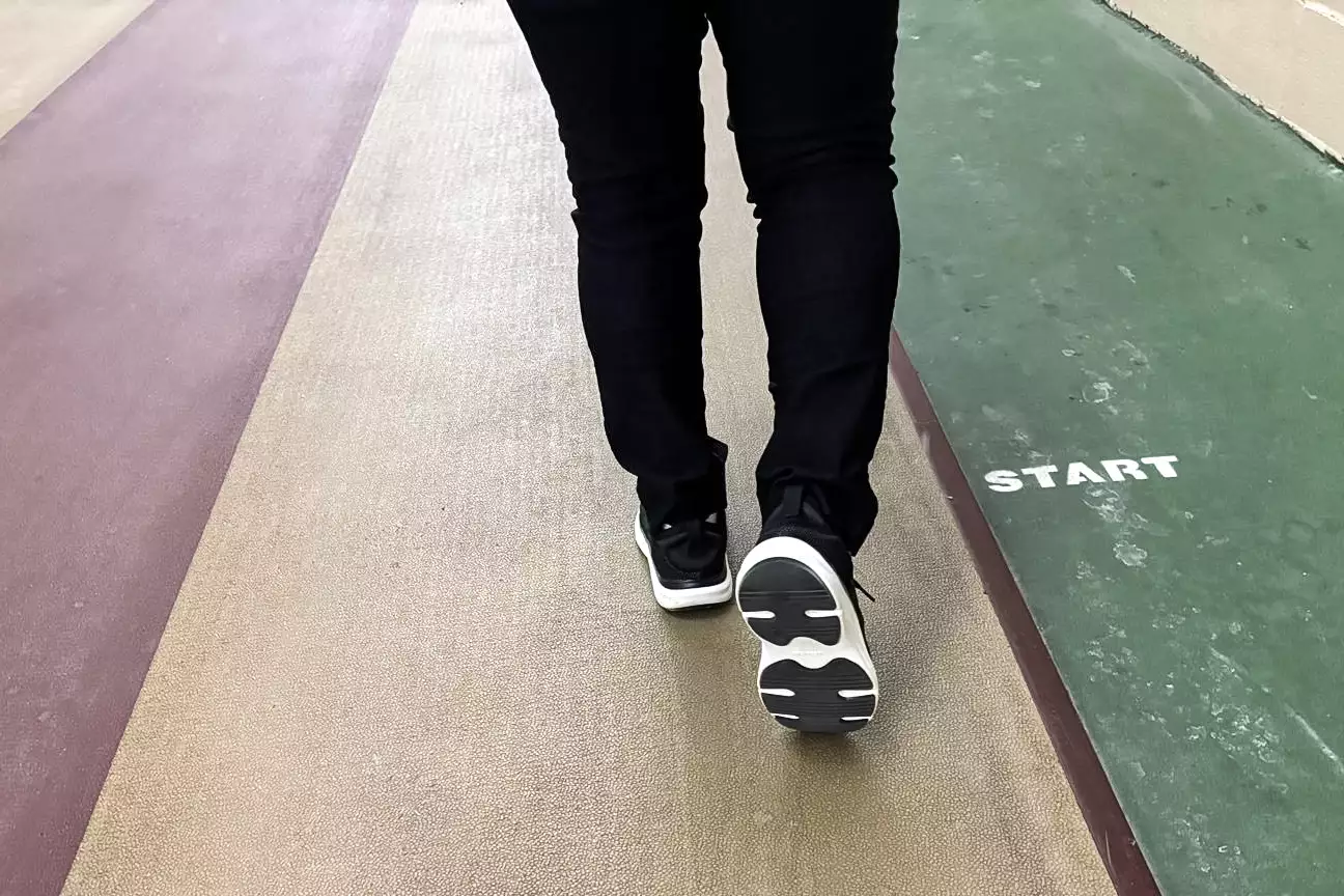 A close-up of a back of a person walking in the Dr. Scholl's Women's Feel Support Lace Up Sneaker