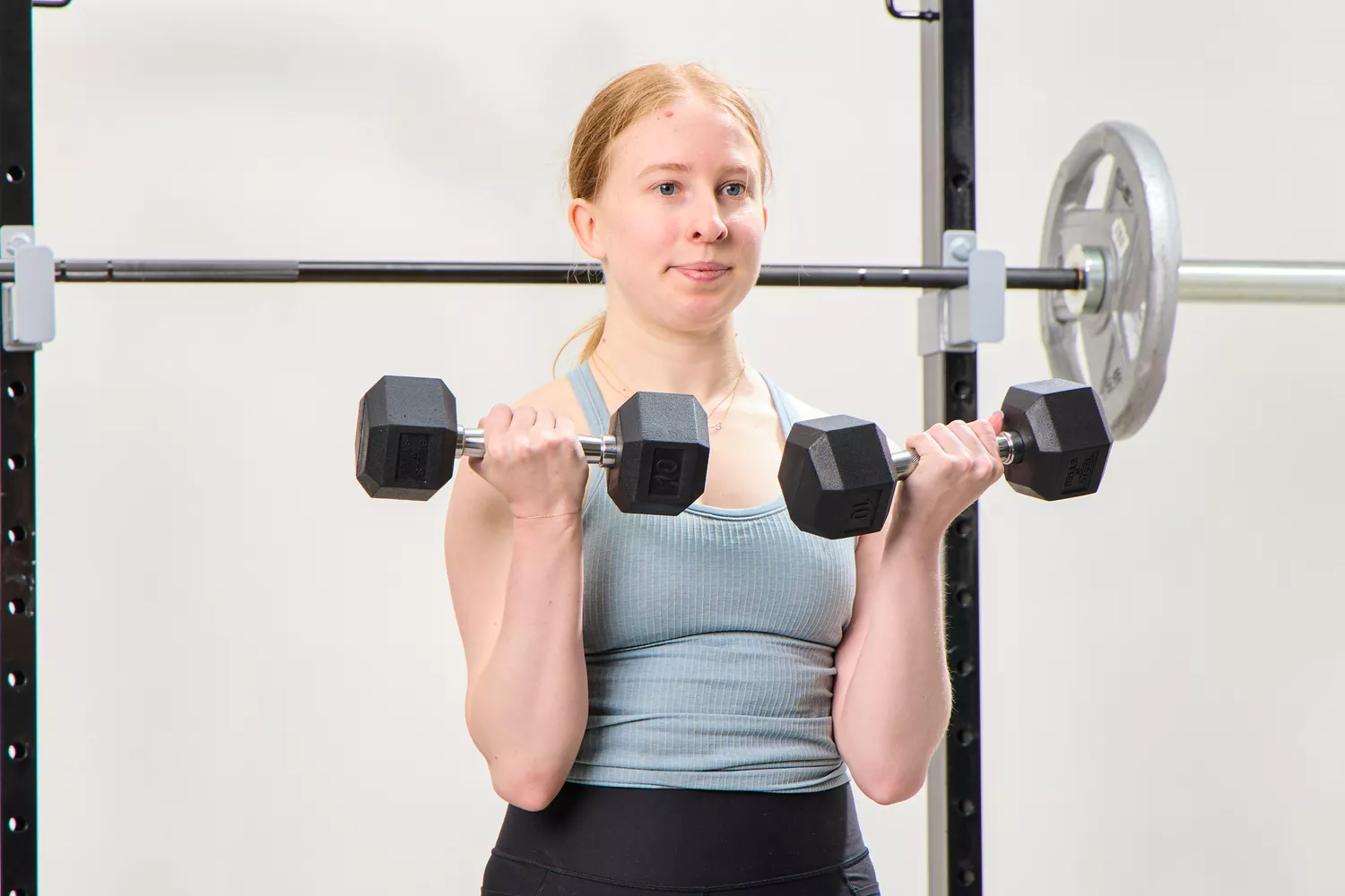 A person does arm curls using the Bells of Steel Ergo Rubber Hex Dumbbells