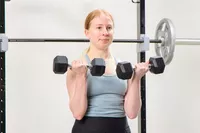 A person does arm curls using the Bells of Steel Ergo Rubber Hex Dumbbells