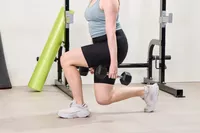A person does squats using the Bells of Steel Ergo Rubber Hex Dumbbells