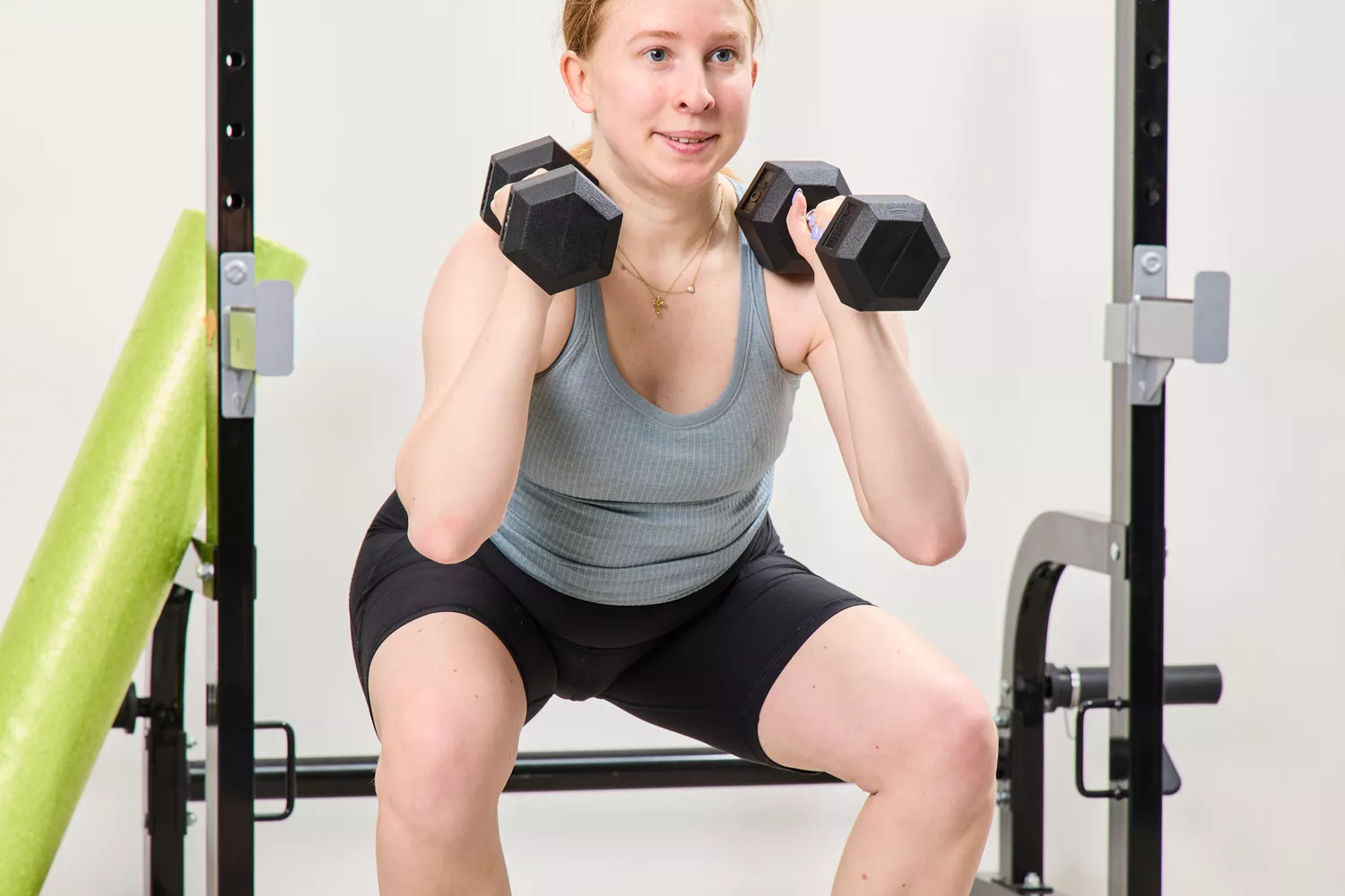 A person squats using the Bells of Steel Ergo Rubber Hex Dumbbells