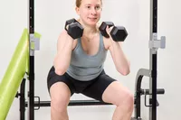 A person squats using the Bells of Steel Ergo Rubber Hex Dumbbells
