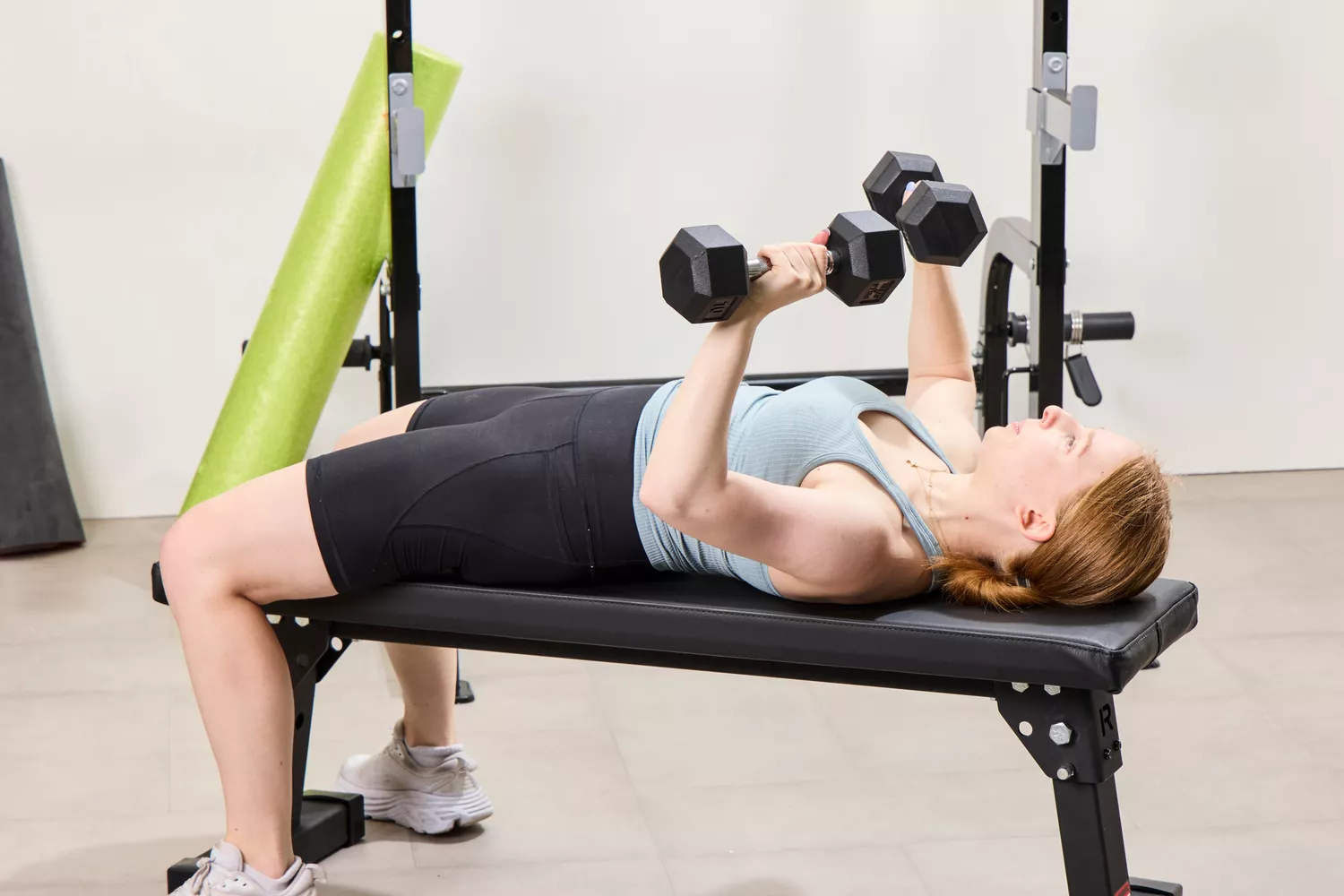 A person does chest presses using the Bells of Steel Ergo Rubber Hex Dumbbells