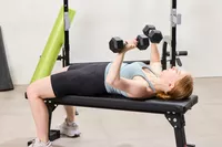 A person does chest presses using the Bells of Steel Ergo Rubber Hex Dumbbells