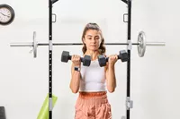 A person does arm curls with the CAP Barbell Neoprene Dumbbells