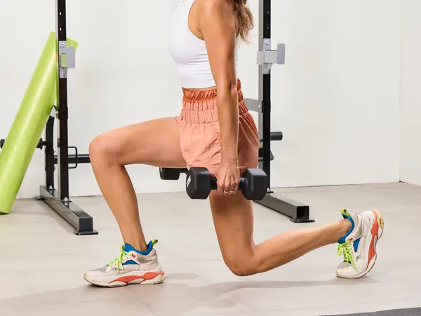 A person squats using the CAP Barbell Neoprene Dumbbells