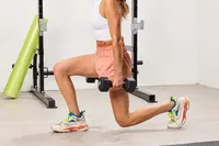 A person squats using the CAP Barbell Neoprene Dumbbells