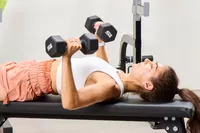 A person does chest presses using the CAP Barbell Neoprene Dumbbells