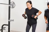 A person lifts the ETHOS Rubber Hex Dumbbells during exercise