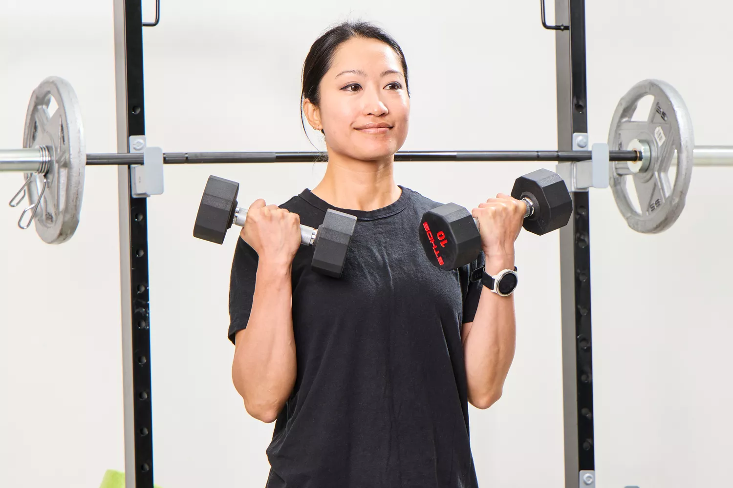 A person lifts the ETHOS Rubber Hex Dumbbells during exercise