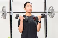 A person lifts the ETHOS Rubber Hex Dumbbells during exercise