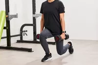 A person lunges with the ETHOS Rubber Hex Dumbbells