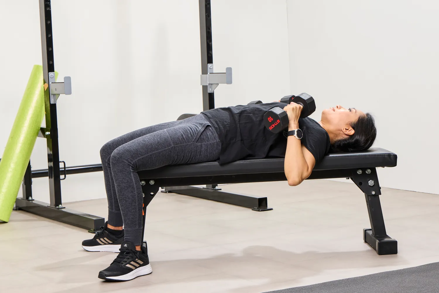 A person does chest presses using the ETHOS Rubber Hex Dumbbells