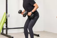 A person holds the REP Fitness Rubber Coated Dumbbells