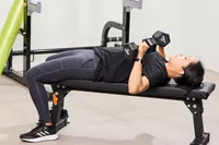 A person lifts the REP Fitness Rubber Coated Dumbbells during exercise