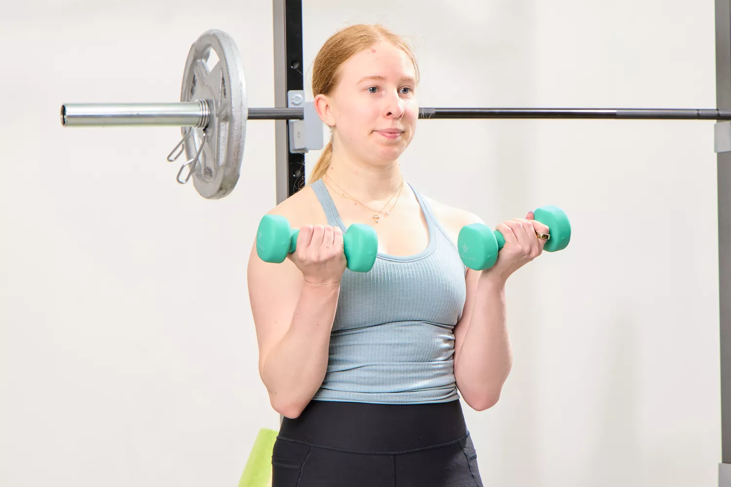 A person does arm curls holding the Yes4All Neoprene Coated Dumbbells