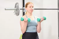 A person does arm curls holding the Yes4All Neoprene Coated Dumbbells