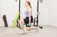 A person lunges while wearing the Yes4All Neoprene Coated Dumbbells