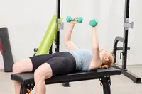 A person does chest presses using the Yes4All Neoprene Coated Dumbbells