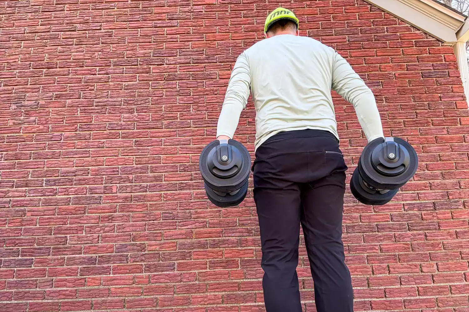 The back of a person wearing the Echelon Strength Adjustable Dumbbells 752 with Stand