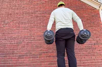 The back of a person wearing the Echelon Strength Adjustable Dumbbells 752 with Stand