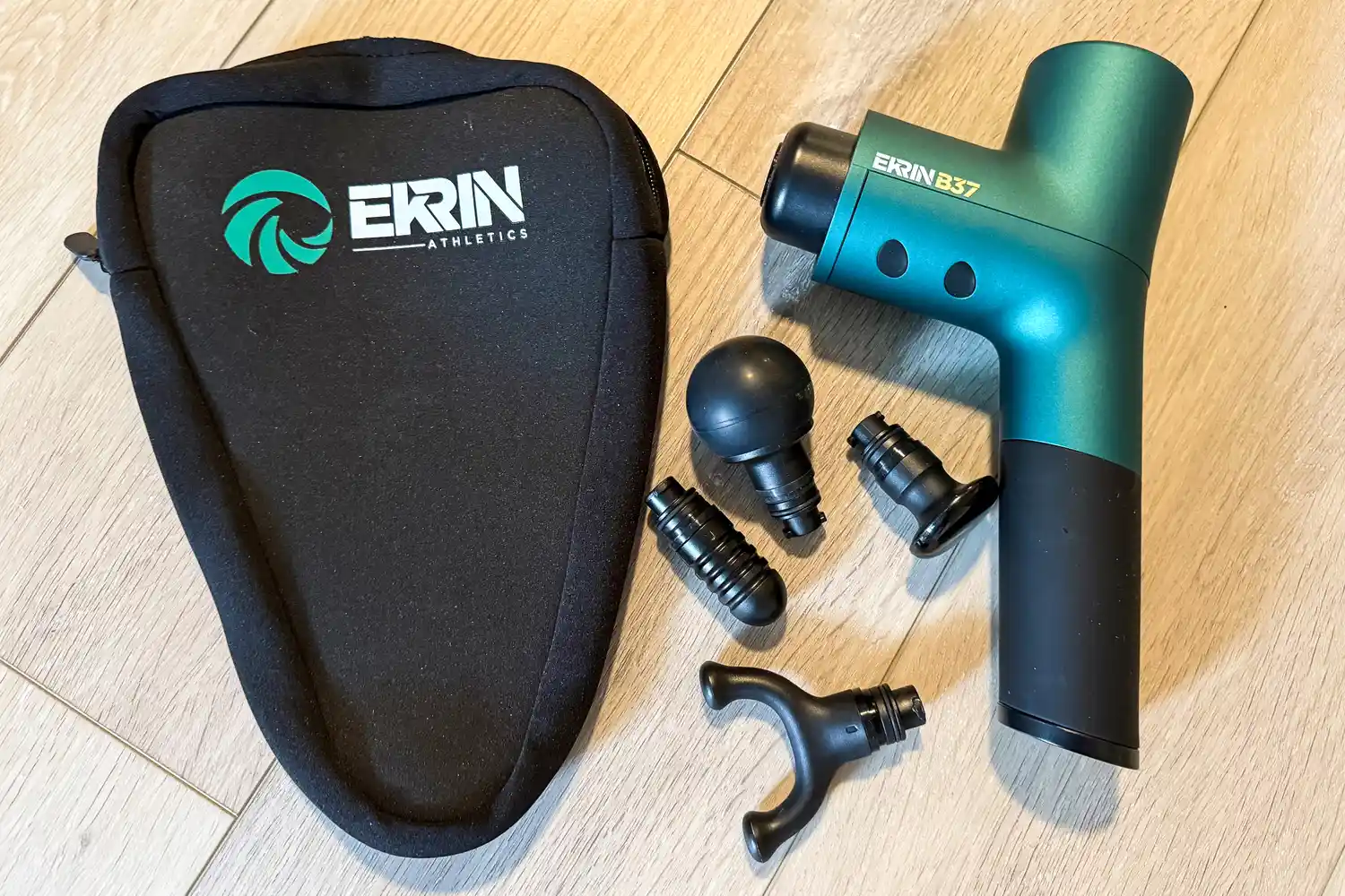 The Ekrin B37 Massage Gun with different attachment heads and a storage bag
