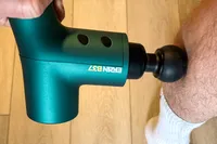 A person uses the Ekrin B37 Massage Gun on their leg