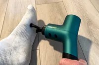 A person uses the Ekrin B37 Massage Gun on their foot