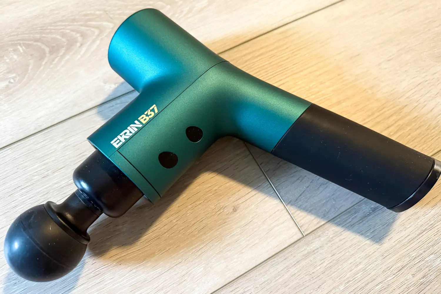 The Ekrin B37 Massage Gun on a tile floor
